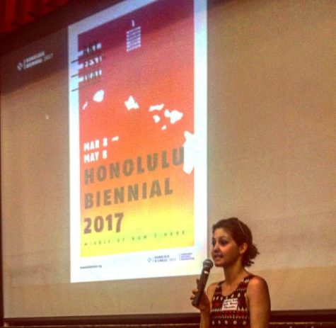 Isabella Hughes in front of the poster for the Honolulu Biennial 2107